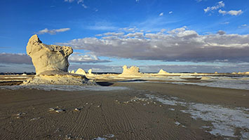 Affioramenti rocciosi scolpiti dal vento nel deserto bianco al tramonto